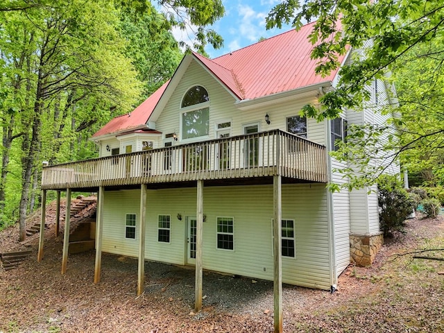 back of property featuring a wooden deck and metal roof