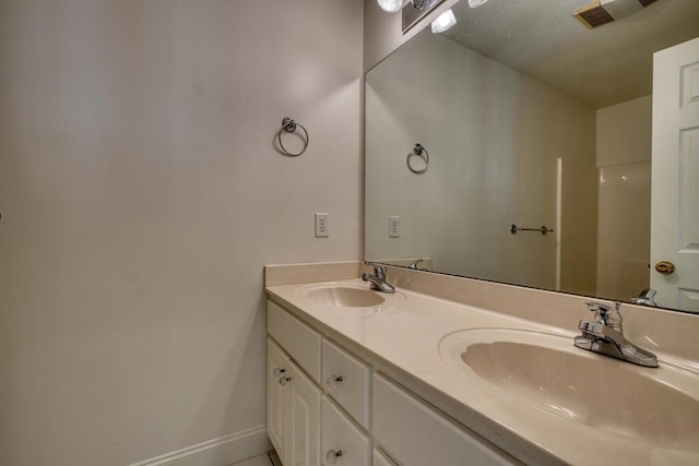 full bath featuring a sink, baseboards, double vanity, and visible vents