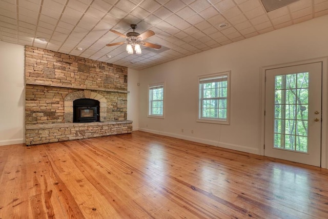 unfurnished living room featuring baseboards, a ceiling fan, a fireplace, and hardwood / wood-style flooring