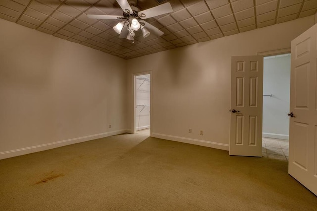 spare room with baseboards, carpet, and ceiling fan