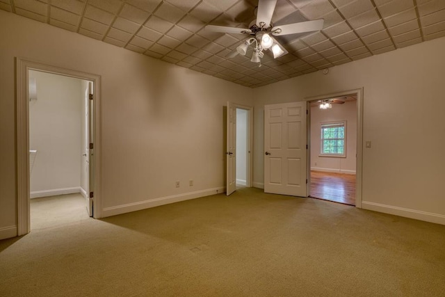 unfurnished room featuring carpet floors, ceiling fan, and baseboards