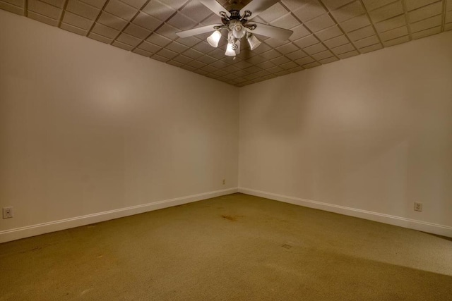 carpeted empty room featuring baseboards and a ceiling fan