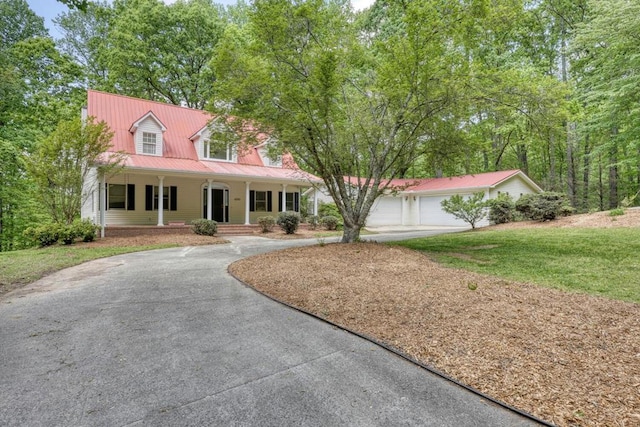 cape cod-style house featuring covered porch, a front lawn, metal roof, and aphalt driveway