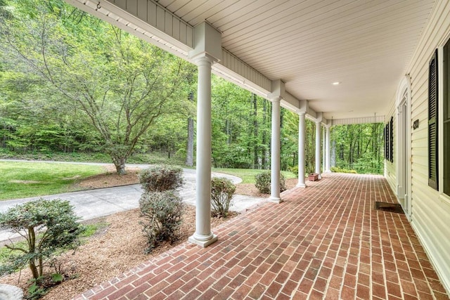 view of patio featuring covered porch and a wooded view
