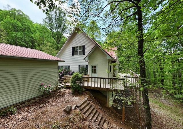 back of property featuring metal roof and a deck