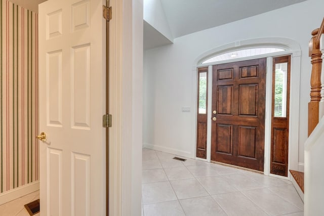 foyer featuring light tile patterned floors, baseboards, and visible vents