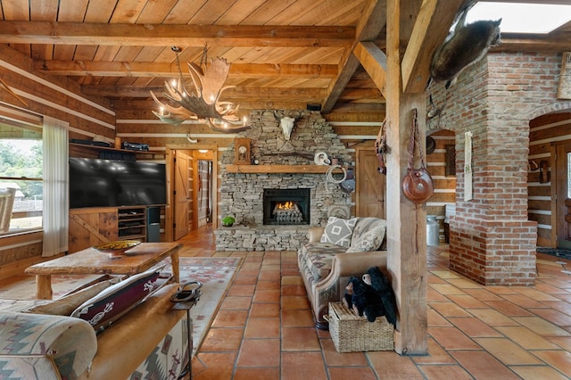 102 Cross Creek Ln, Warne, NC 28909 - tiled living room featuring a wooden ceiling with exposed beams, a fireplace, wood walls, and a chandelier