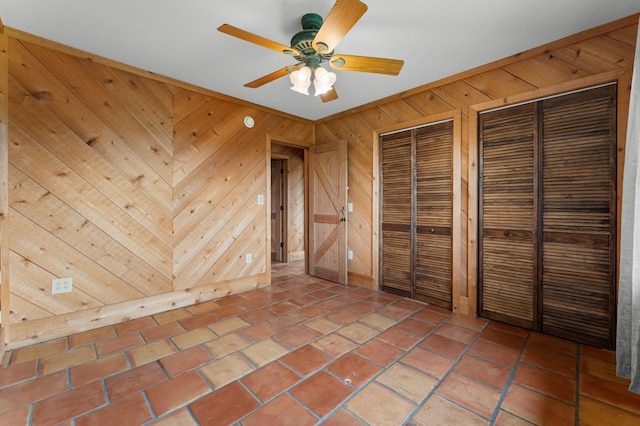 102 Cross Creek Ln, Warne, NC 28909 - unfurnished bedroom featuring two closets, wooden walls, and a ceiling fan