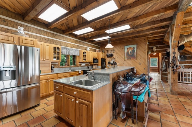 102 Cross Creek Ln, Warne, NC 28909 - kitchen with stainless steel fridge with ice dispenser, wooden walls, a center island with sink, a wood ceiling with exposed beams, and glass insert cabinets