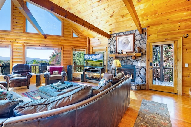 living room featuring a fireplace, beam ceiling, light wood-type flooring, and high vaulted ceiling