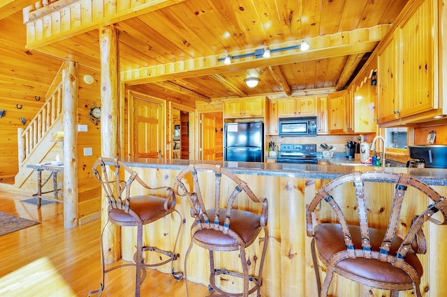 192 Oak Ridge Way, Morganton, GA 30560 - kitchen featuring black appliances, wooden ceiling with exposed beams, light wood-type flooring, a peninsula, and wood walls