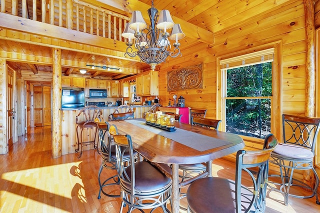 dining area featuring light hardwood / wood-style floors, a chandelier, beam ceiling, and wooden ceiling