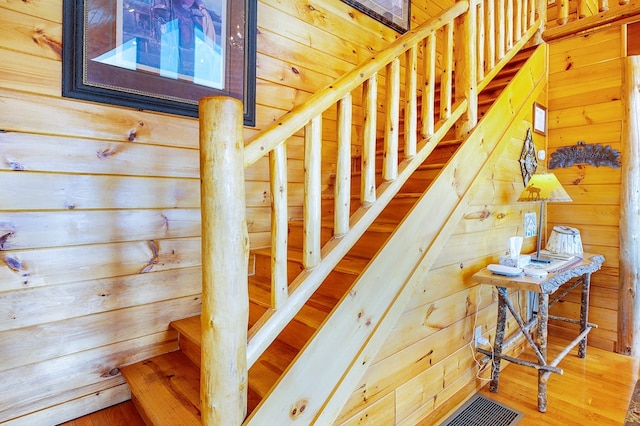 stairs featuring wooden walls and wood-type flooring