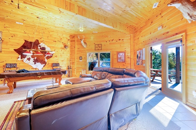 tiled living room with plenty of natural light, wooden walls, and pool table