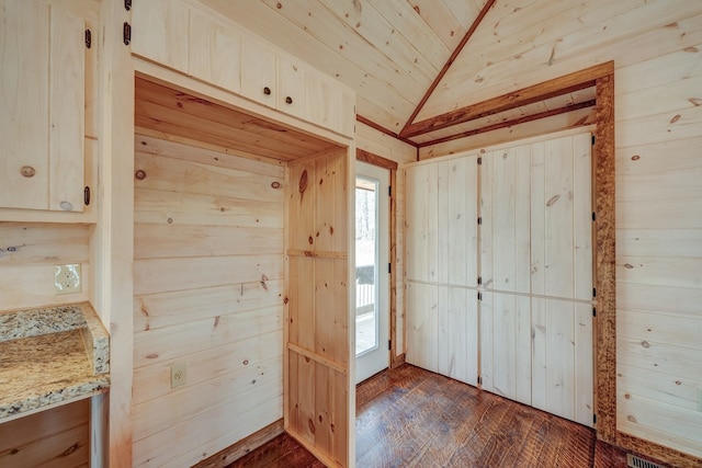 interior space featuring dark hardwood / wood-style flooring, wood ceiling, wood walls, and lofted ceiling