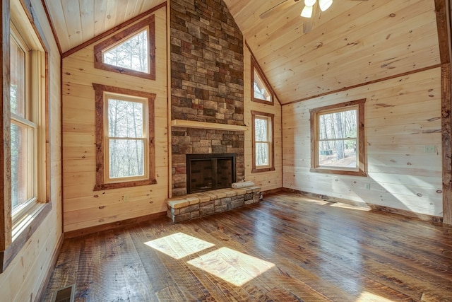 unfurnished living room featuring a stone fireplace, dark hardwood / wood-style flooring, wooden ceiling, high vaulted ceiling, and wooden walls