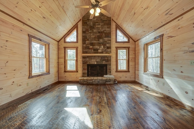 unfurnished living room featuring wooden ceiling, a stone fireplace, wood-type flooring, and wooden walls