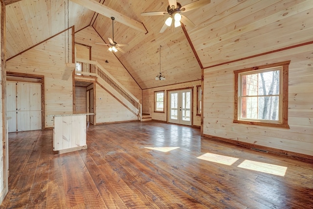 unfurnished living room with french doors, dark hardwood / wood-style floors, wooden ceiling, high vaulted ceiling, and wooden walls