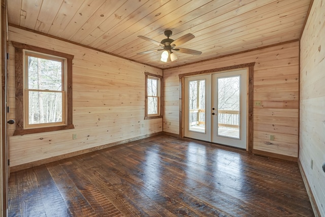 empty room with french doors, wooden walls, wood ceiling, and dark hardwood / wood-style floors