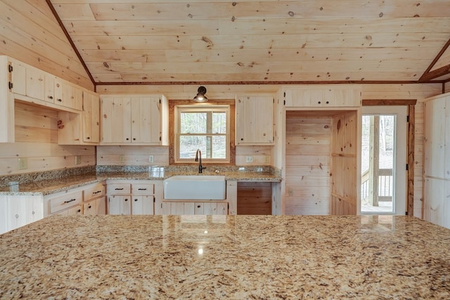 kitchen with vaulted ceiling, light stone countertops, wood ceiling, and sink