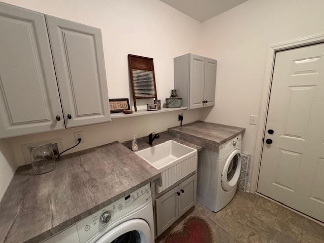 laundry room with cabinets, washing machine and dryer, and sink