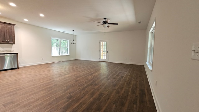 unfurnished living room with ceiling fan with notable chandelier, visible vents, recessed lighting, dark wood-style flooring, and baseboards