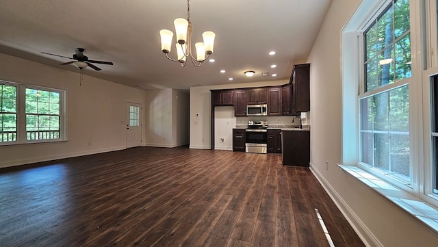 unfurnished living room featuring dark wood-style flooring, baseboards, recessed lighting, ceiling fan with notable chandelier, and a sink