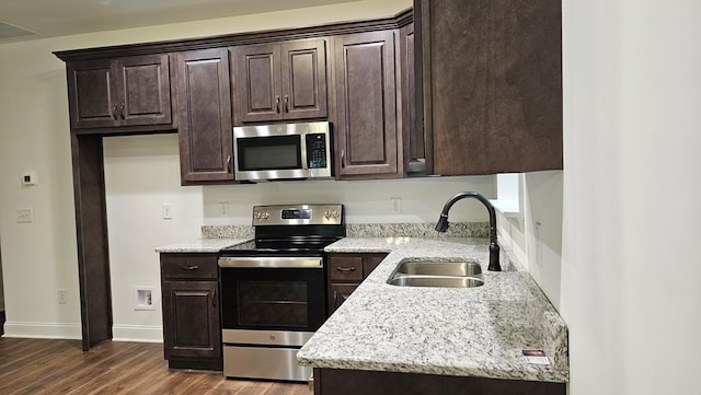 kitchen with stainless steel appliances, a sink, and dark brown cabinets