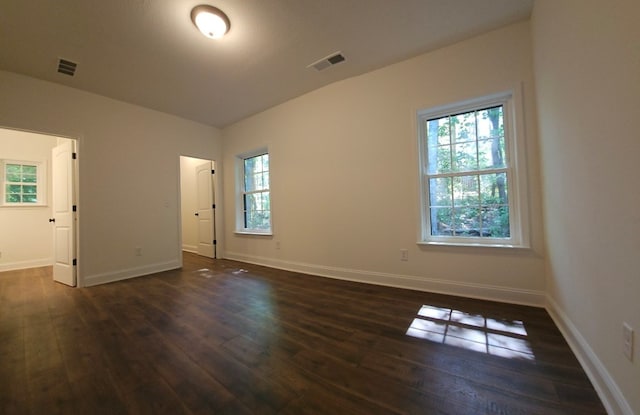 interior space with a healthy amount of sunlight, vaulted ceiling, and dark hardwood / wood-style flooring