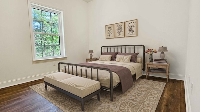 bedroom with hardwood / wood-style flooring and baseboards