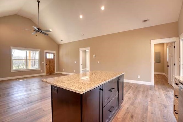 kitchen with light stone counters, dark brown cabinets, ceiling fan, high vaulted ceiling, and light hardwood / wood-style floors