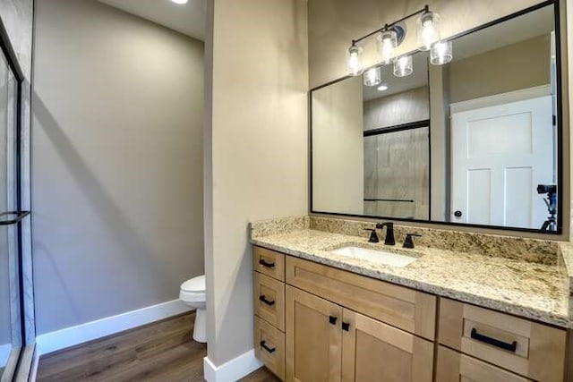 bathroom featuring vanity, hardwood / wood-style flooring, and toilet