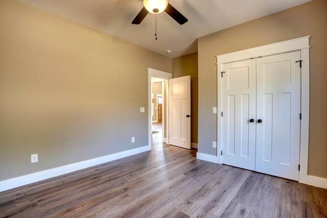 unfurnished bedroom featuring ceiling fan, light hardwood / wood-style floors, and a closet