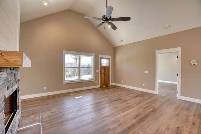 unfurnished living room with a fireplace, ceiling fan, hardwood / wood-style floors, and high vaulted ceiling