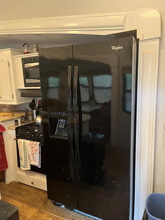 142 Gander Gap Rd, Hiawassee, GA 30546 - kitchen with gas stove, white cabinets, light countertops, built in microwave, and black refrigerator with ice dispenser