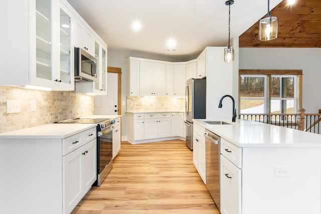 kitchen featuring stainless steel appliances, sink, pendant lighting, light hardwood / wood-style flooring, and white cabinetry