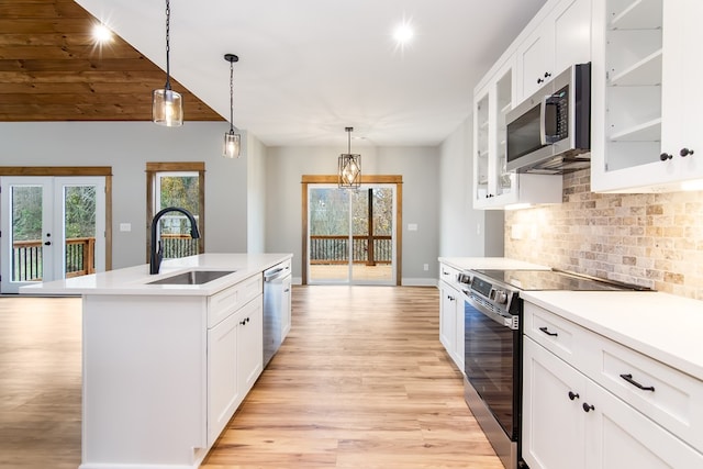 kitchen featuring white cabinets, a kitchen island with sink, and appliances with stainless steel finishes