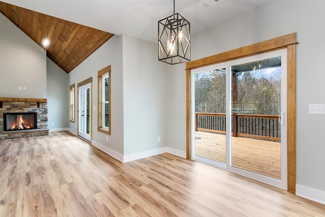 unfurnished living room with a notable chandelier, wooden ceiling, and light hardwood / wood-style flooring