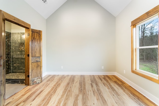 empty room featuring light wood-type flooring and lofted ceiling