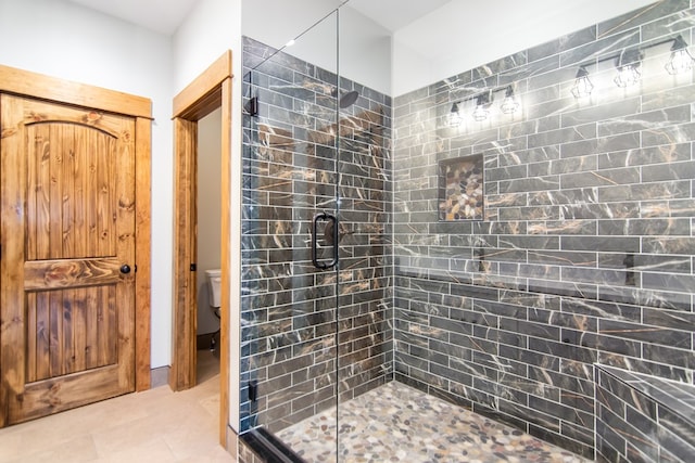 bathroom featuring an enclosed shower, tile patterned flooring, and toilet