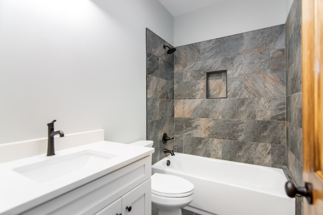 full bathroom with vanity, tiled shower / bath combo, and toilet