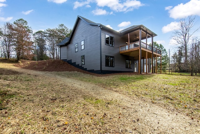 rear view of property with ceiling fan, a yard, and a deck