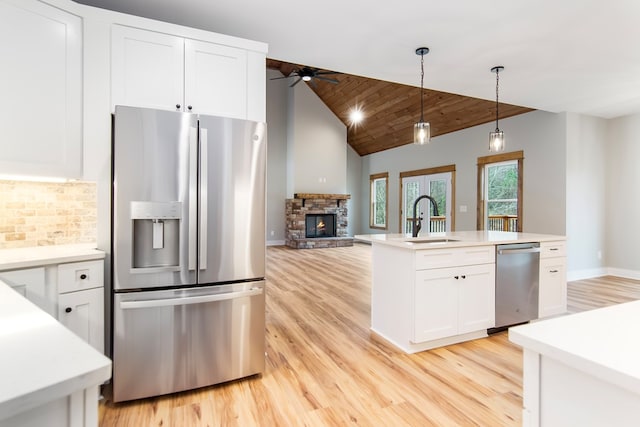 kitchen featuring wood ceiling, stainless steel appliances, vaulted ceiling, ceiling fan, and white cabinetry