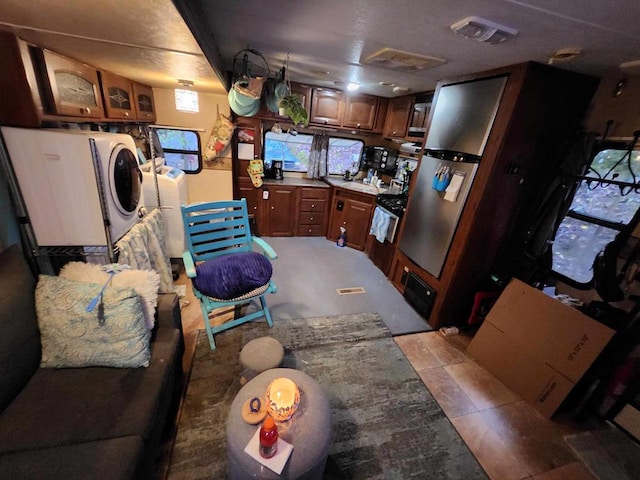 kitchen featuring washing machine and dryer, brown cabinets, glass insert cabinets, and visible vents