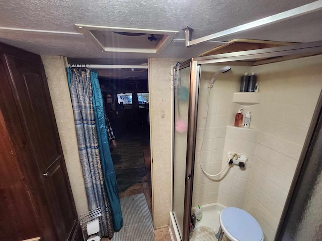 full bath featuring a shower stall and a textured ceiling
