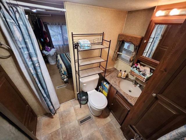 bathroom featuring visible vents, toilet, and vanity