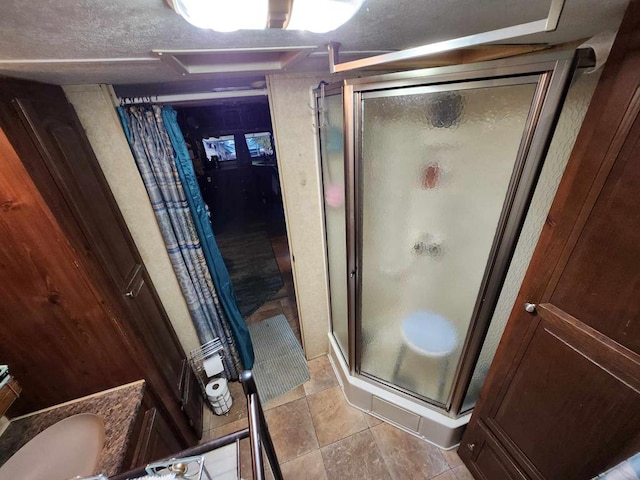 bathroom with a stall shower and a textured ceiling