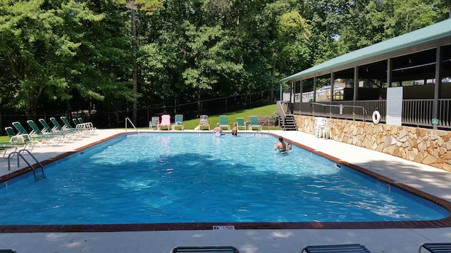 community pool with fence and a patio