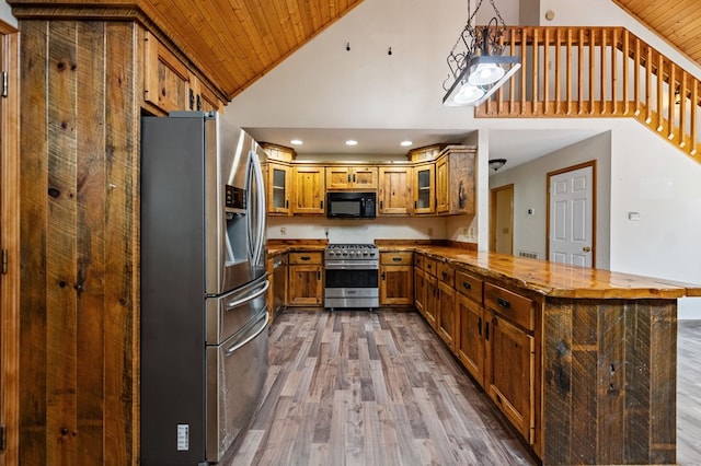 kitchen with dark hardwood / wood-style floors, decorative light fixtures, wooden ceiling, stainless steel appliances, and kitchen peninsula