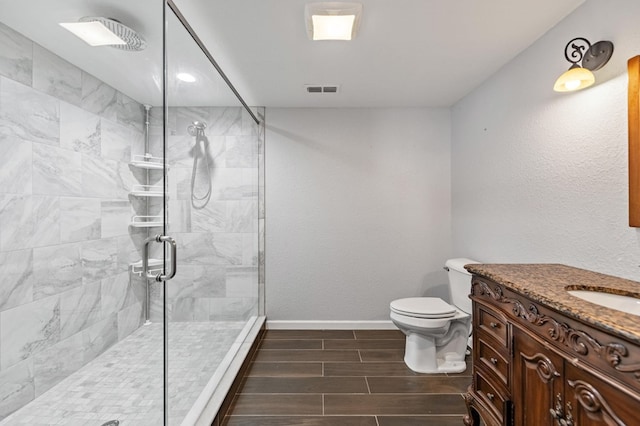 bathroom featuring vanity, toilet, and an enclosed shower